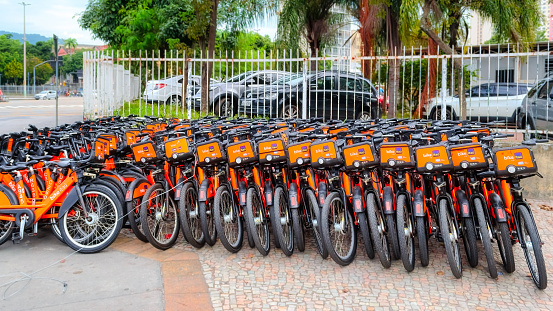 Rio de Janeiro, Brazil - June 15, 2023: Itau Bike Sharing System. Parked rental bicycles in the city. The orange bikes are for green transportation.
