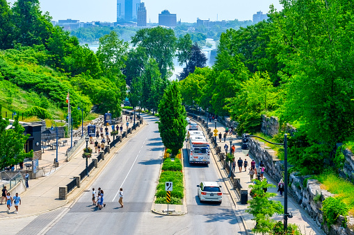 Niagara Falls, Ontario, Canada - June 17, 2023: Ariel view of a street with pedestrians. Vehicles are on the road. The Niagara Falls spray is in the distance