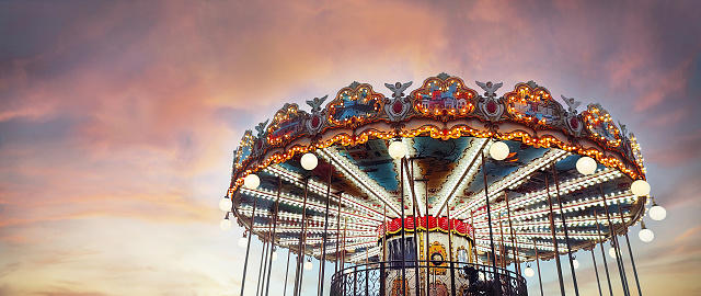 Part of popular vintage, retro carousel (merry-go-round) by the Eiffel Tower in Paris on sky sunset background. France. Copy space. Empty space for your message.