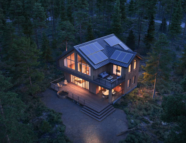 3d render of modern forest house with solar panels on roof at night stock photo