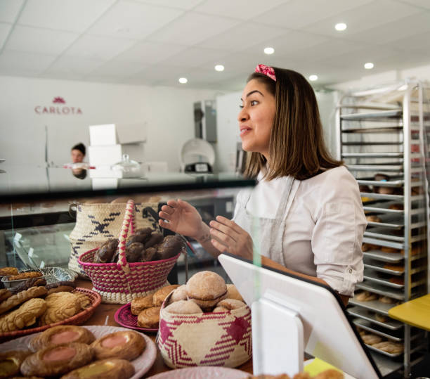 istock Small local bakery shop owner presenting freshly baked pastries. 1516938729