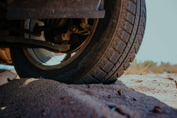 istock Car wheel on sand close-up view 1516953420