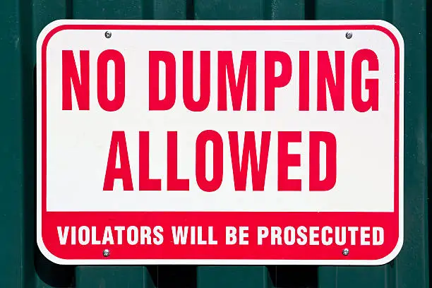 No dumping sign on a metal wall.