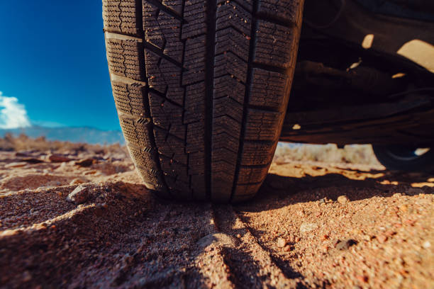 istock Car wheel on sand close-up view 1516980121