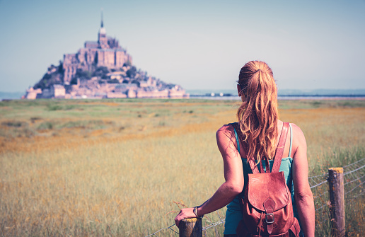 Woman tourist enjoying beautiful view of Mont Saint Michel- Normandie in France