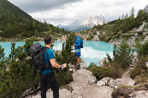 Caucasian man admiring the beauty of the turquoise-colored Sorapis Lake, during group hike