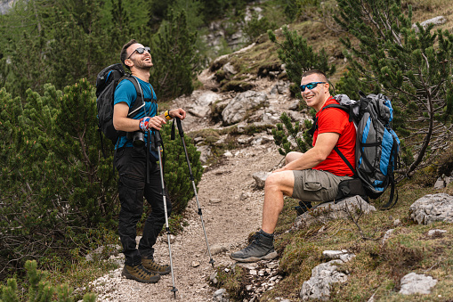 Caucasian men, admiring the beauty of nature, during their hike through Dolomites