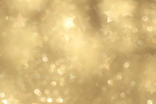 Yellow Christmas lights and stars as a bokeh background.