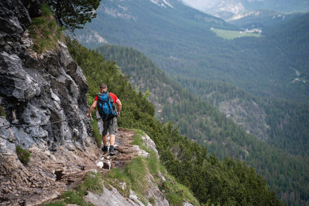 istock Unrecognizable man, hiking through mountain on a narrow footpath 1517014832