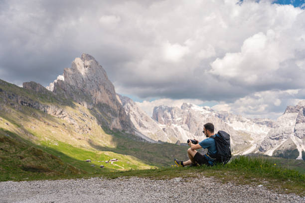istock Caucasian man, taking a break from hiking while photographing with camera the beauty of Dolomites 1517014849