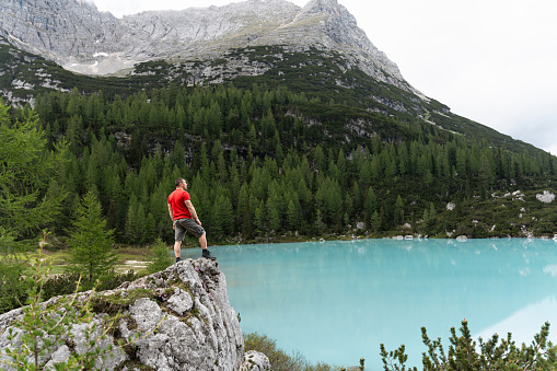 Caucasian man admiring the beauty of the turquoise-colored Sorapis Lake
