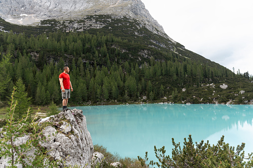Caucasian man admiring the beauty of the turquoise-colored Sorapis Lake