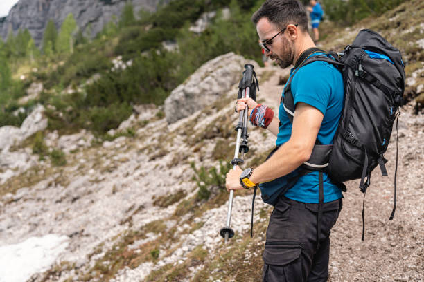 istock During group hike, Caucasian man adjusting his hiking poles 1517017729