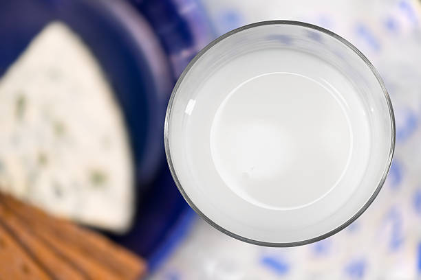 Glass of milk from above with cheese in backgound