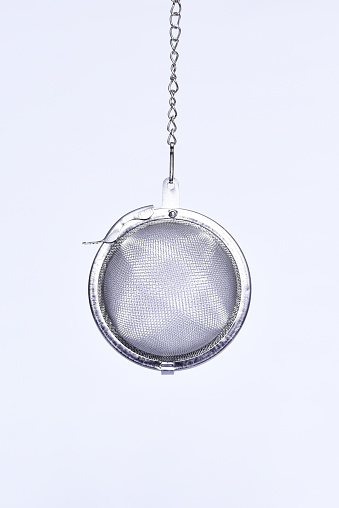 stainless steel tea infuser for hot water metal strainer isolated on white background.
