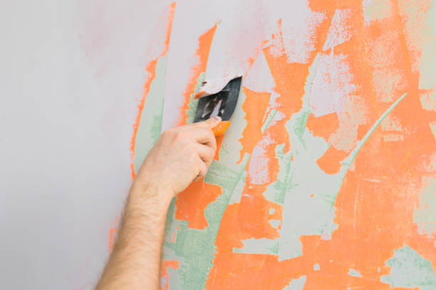 istock Close up man smoothes wall surface with a wall grinder. Male grind a white plaster wall - renovation and redecoration concept. Copy space and empty space for text 1517039580