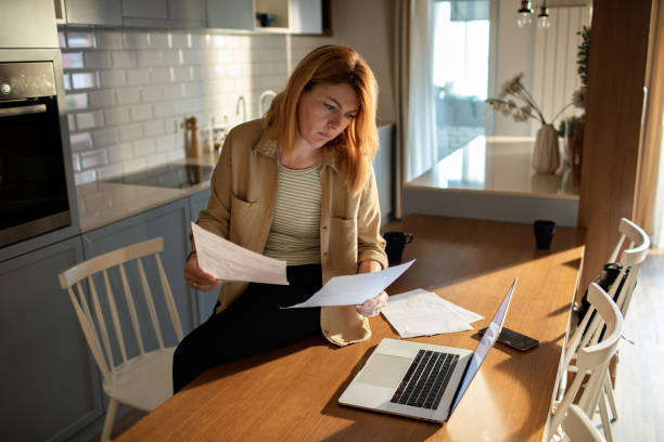 istock Young woman going over her finances at home while using her laptop 1517041206