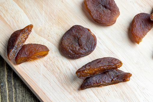 Naturally dried ripe apricots, fresh and very sweet dried apricots on a wooden board