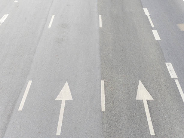 istock The white painted arrow on the highway for direction. 1517090904