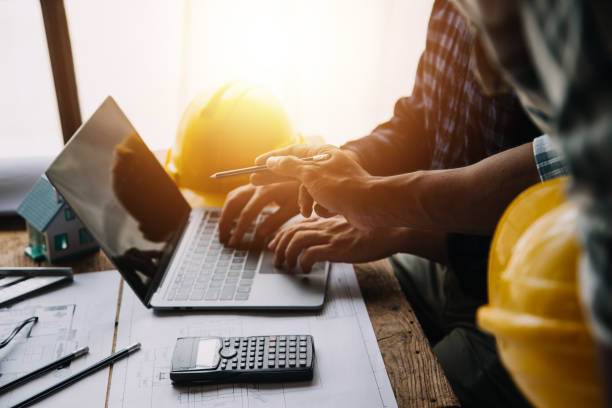 istock Construction and structure concept of engineer working drawing on blueprint meeting for project working with partner on model building and engineering tools in working site, construction concept 1517094813