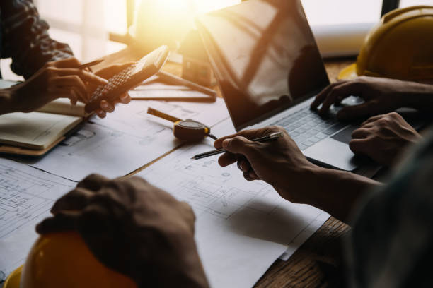 istock Construction and structure concept of engineer working drawing on blueprint meeting for project working with partner on model building and engineering tools in working site, construction concept 1517094841