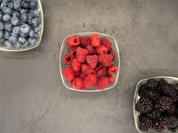 istock raspberries and blueberries in bowls on black slate 1517105184