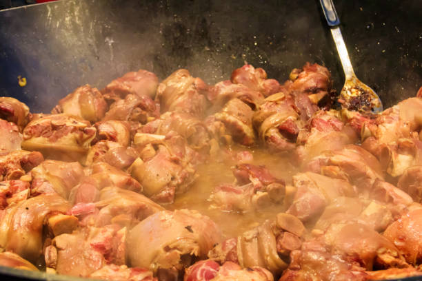 cooking of pork knuckle (traditional german dish) in big cauldron - shank sauerkraut german cuisine pork imagens e fotografias de stock