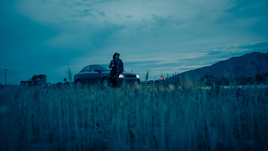 Cinematic scene of a car with a man in a hat and jacket