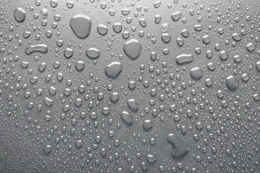 Close-up of water drops on silver surface, wet background