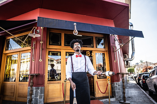 Waiter juggling with pins in front of reastaurant