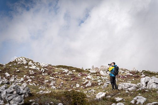 Caucasian man with camera, photographing Dolomites Tre Cime di Lavaredo, during hike