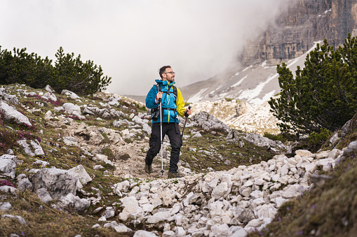 Caucasian man, hiking through the Dolomites, during cloudy day