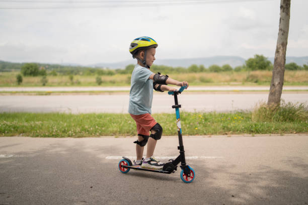 istock Little boy riding scooter. Kids ride kick board 1517235626