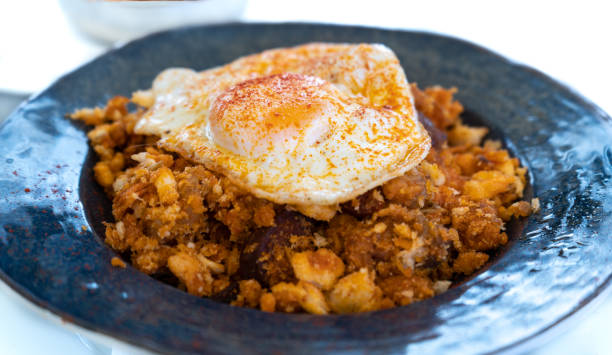 Typical Spanish dish called "migas extremeñas", made with crumbs, meat, paprika, egg, oil and garlic stock photo