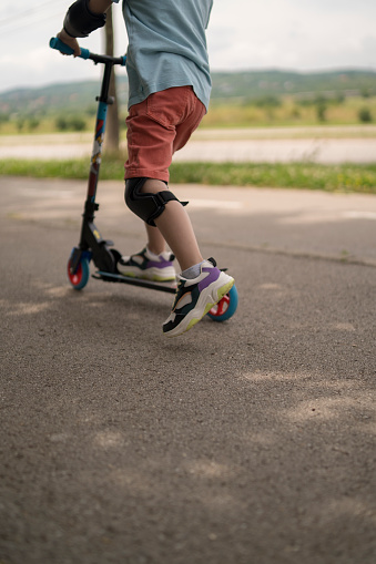 Little boy riding scooter. Kids ride kick board