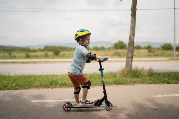 istock Little boy riding scooter. Kids ride kick board 1517237613
