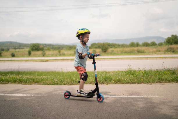 istock Little boy riding scooter. Kids ride kick board 1517238136