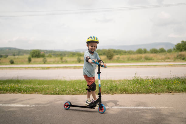 istock Little boy riding scooter. Kids ride kick board 1517239245