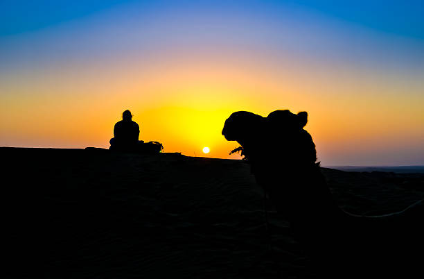 istock Woman and a camel at sunset on the Thar Desert 151723967