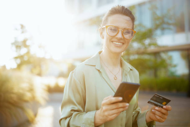 istock female worker in green blouse and eyeglasses using smartphone 1517256189