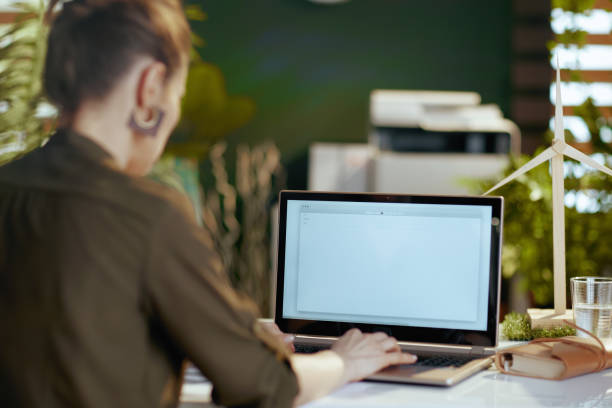 istock Seen from behind modern woman with laptop writing email 1517286808