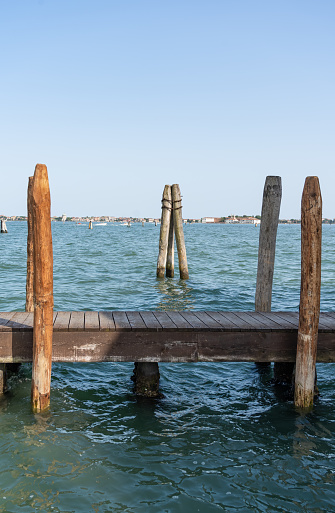 A wooden mooring pier and mooring piles on the Grand Canal in Venice, Italy.