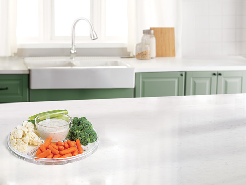 Veggie platter in a kitchen with a marble counter top and sink in the background