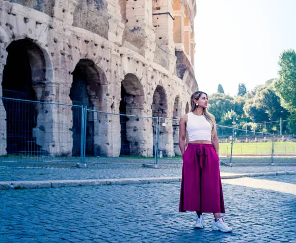 Young woman strolling through the Roman Colosseum on a summer's day