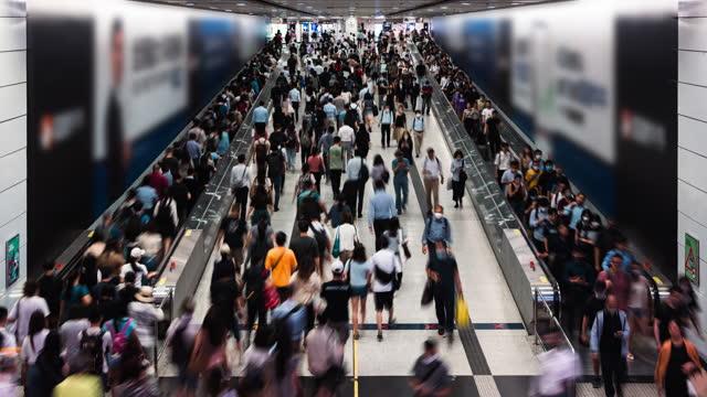 Timelapse of Asian people walk on travelator escalator at Central subway underground station in Hong Kong. Public transportation, Asia city life, or commuter urban lifestyle concept. High angle view