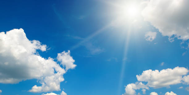istock Bright sun on beautiful blue sky with white clouds. 1517450860
