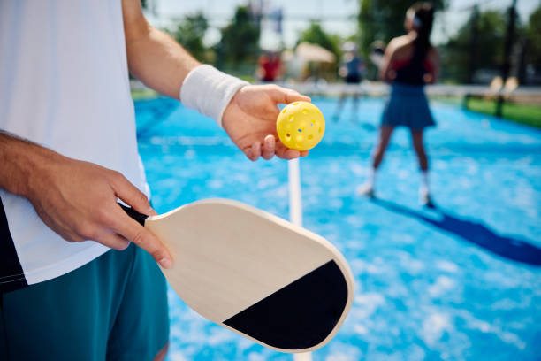 istock Close up of man serving the ball while playing mixed doubles in pickleball. 1517469876