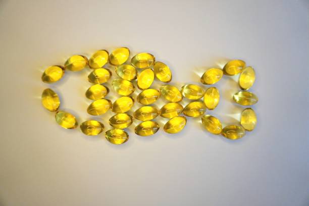 fish oil capsules creates fish shape. Fish oil capsules are a dietary supplement that contains omega-3 fatty acids. Omega-3 fatty acids are essential fats that are found in certain types of fish, such as salmon, mackerel, and sardines. These fatty acids have been shown to have numerous health benefits, including supporting heart health, brain function, and reducing inflammation in the body. kumquat underwater stock pictures, royalty-free photos & images