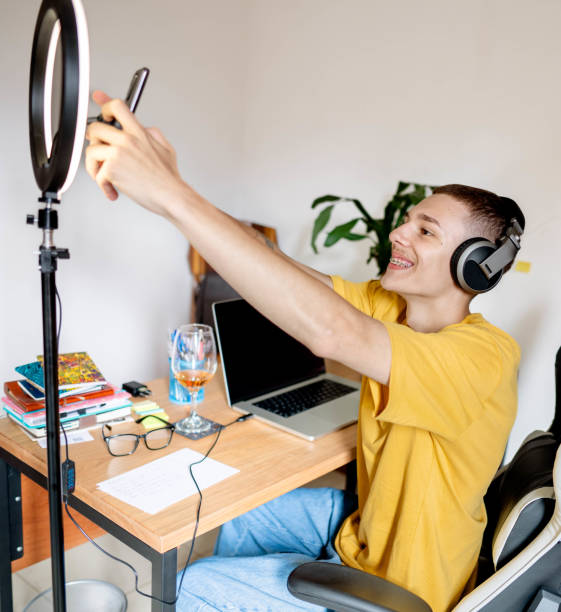 istock Young man adjusting his smart phone before doing a vlog from home 1517516310
