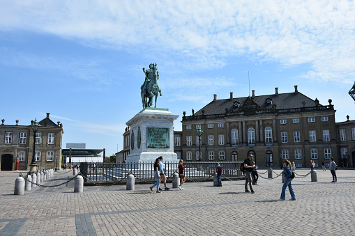 Copenhagen, Denmark - May 14, 2023: Amalienborg Palace, Equestrian statue Of Frederick V, People Walking, Taking Picture During Springtime In Scandinavia Northern Europe